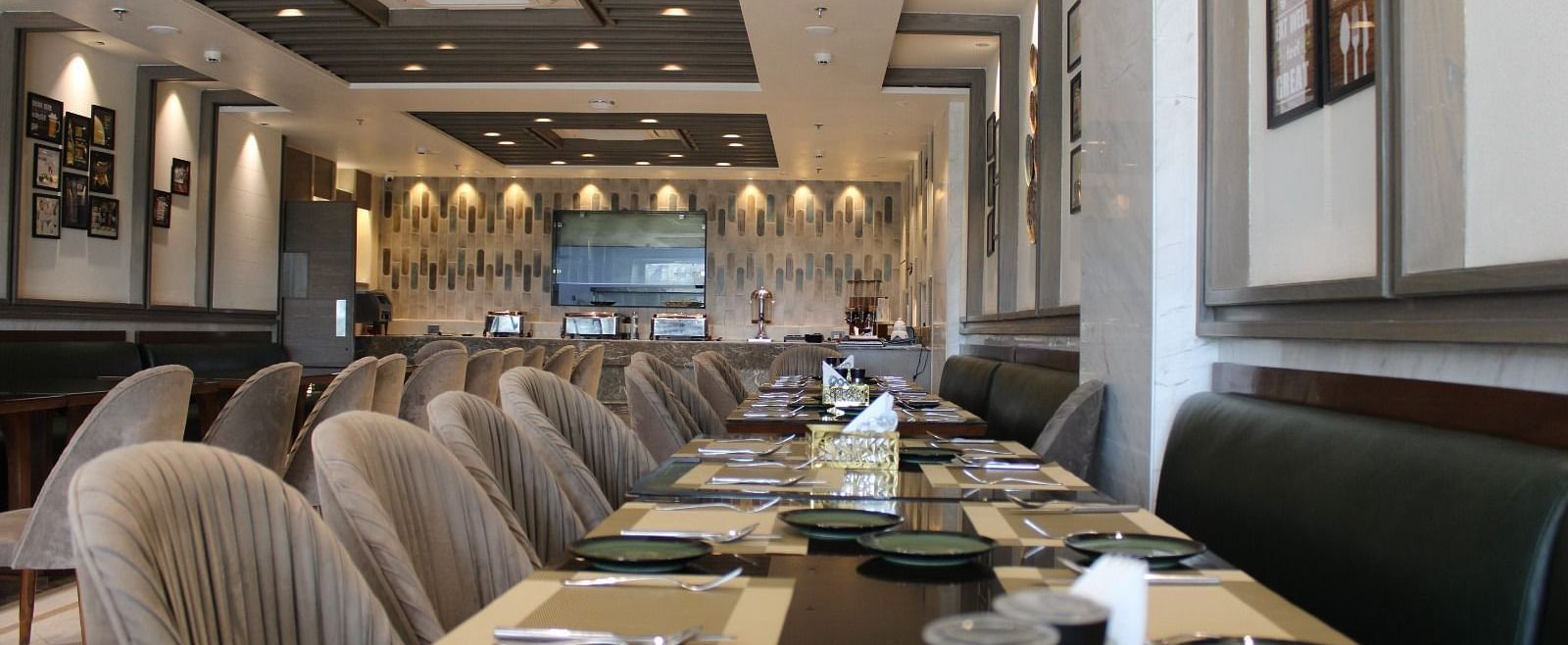 A well-arranged dining space featuring tables with chairs and neatly set cutlery at  BluSalzz Residence, Amritsar